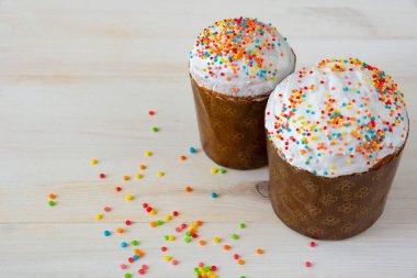 Renkli soslu Paskalya pastaları. Ahşap arka planda renkli kremalı ev yapımı Paskalya pastaları.