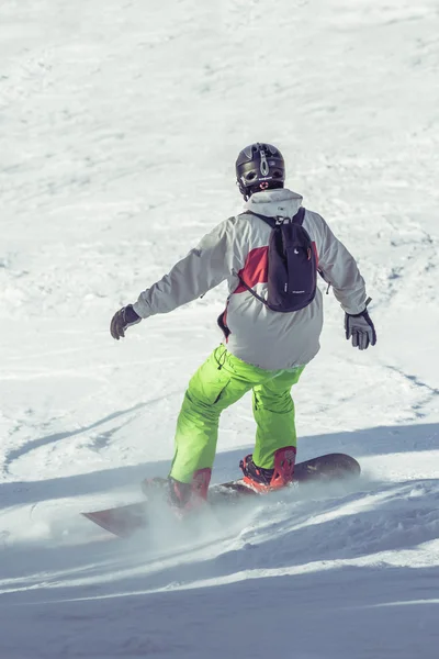 Young snowboarder sliding on ski slope — Stock Photo, Image