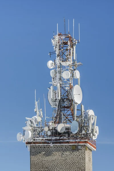 Телекомунікаційна вежа з тарілкою та мобільними антенами — стокове фото