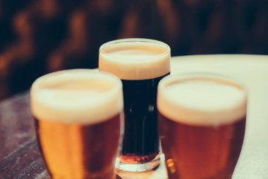 Bar arka planında açık ve koyu bira bardakları.