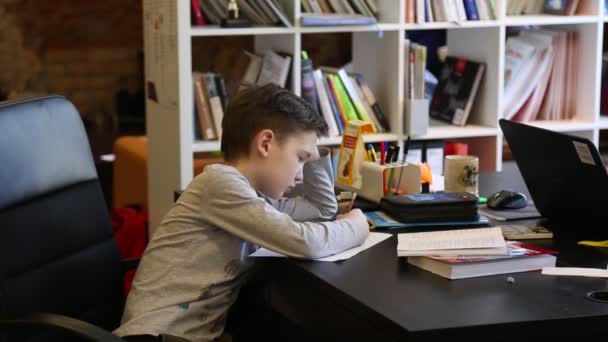 Moskau - 23. März 2016: Das Kind erledigt seine Hausaufgaben am Tisch. — Stockvideo