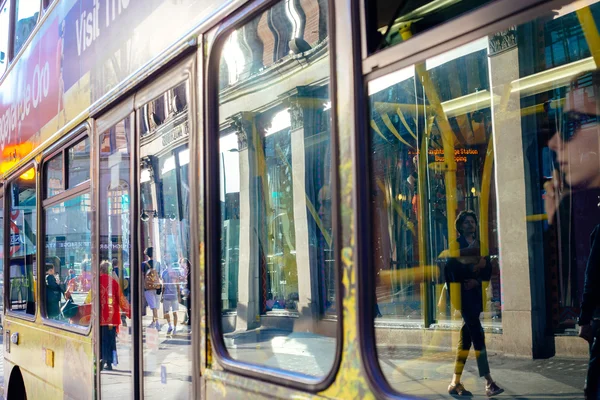 LONDON, UK - April 14, 2015:  Reflection of people in the bus window on a sunny day.