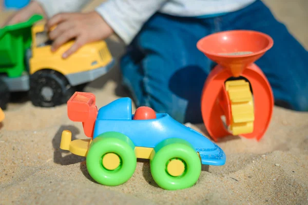 El chico se divierte al aire libre. Niño jugando juguetes en el soleado fondo del día de verano — Foto de Stock