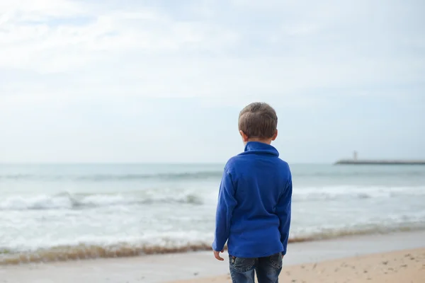 Voltar vista retrato de menino bonito na praia no fundo do oceano — Fotografia de Stock