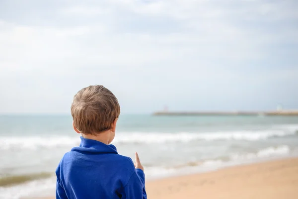 Voltar vista retrato de menino bonito na praia no fundo do oceano — Fotografia de Stock