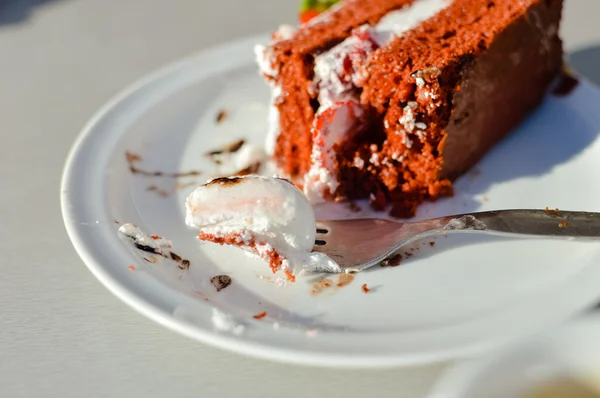 Шматочок шоколадного торта з свіжою ягодою на фоні білої тарілки, крупним планом — стокове фото