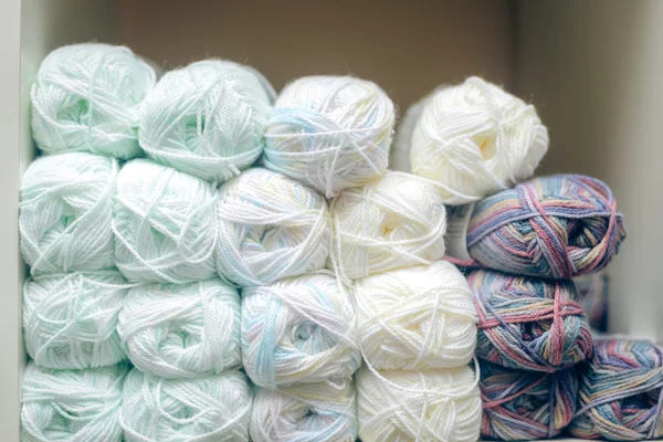 Bolas brancas de lã ou fios de algodão empilhados na prateleira da loja — Fotografia de Stock