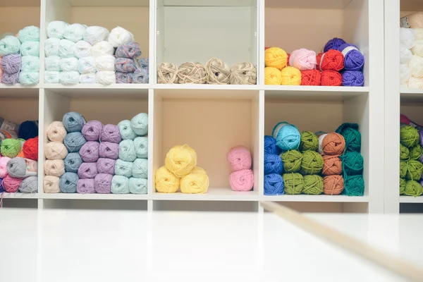 Bolas coloridas de lã ou fios de algodão empilhados na prateleira da loja — Fotografia de Stock