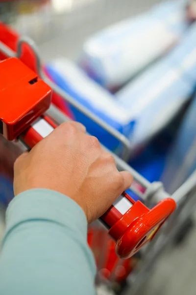 Mano masculina con carrito de compras. Primer plano. — Foto de Stock