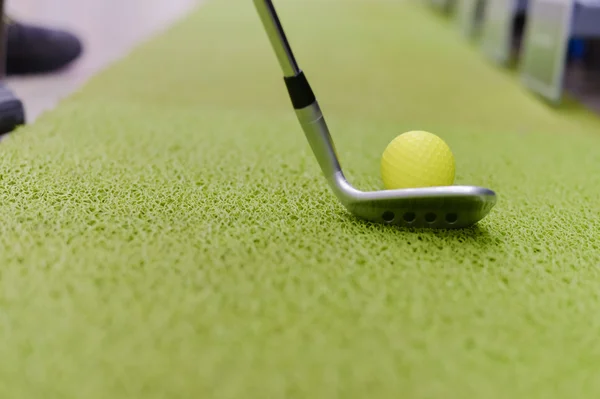 Golfschläger und Ball auf grünem Indoor-Gras Hintergrund — Stockfoto