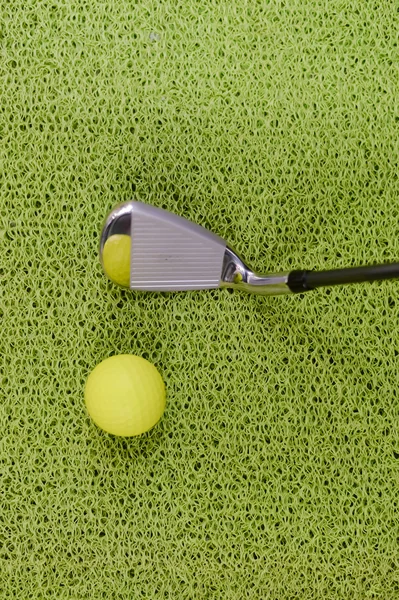 Golfschläger und Ball auf grünem Indoor-Gras Hintergrund — Stockfoto