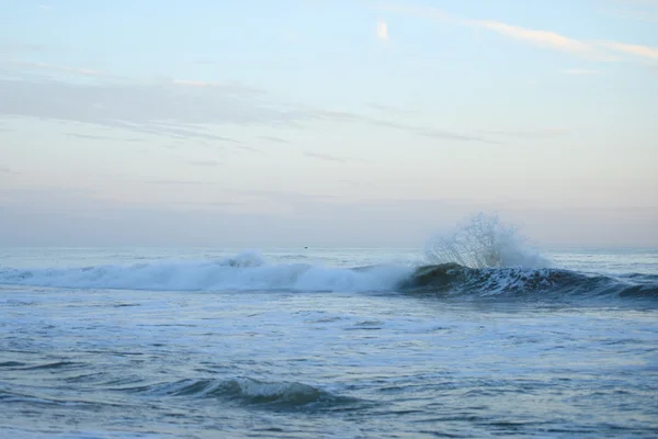 Onde oceaniche sulla spiaggia all'ora del tramonto — Foto Stock