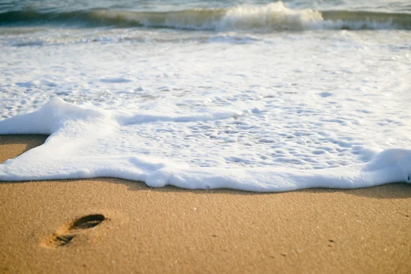 Sunny footprint on the sand and white wave background. swim walk — Stock Photo, Image