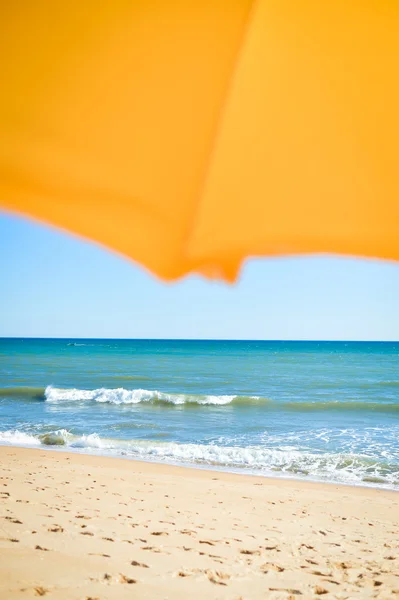 Vista de vacaciones de sombrilla, playa de arena y fondo de la orilla del océano — Foto de Stock