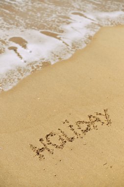 Deniz kum plaj güneş ışınlarına karşı dalga köpüğü ile üstten görünüm üzerinde yazıt tatil. tatil kavramı