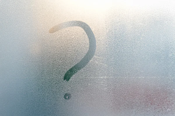Концепция знака вопроса, надпись на туманном стеклянном фоне крупным планом — стоковое фото