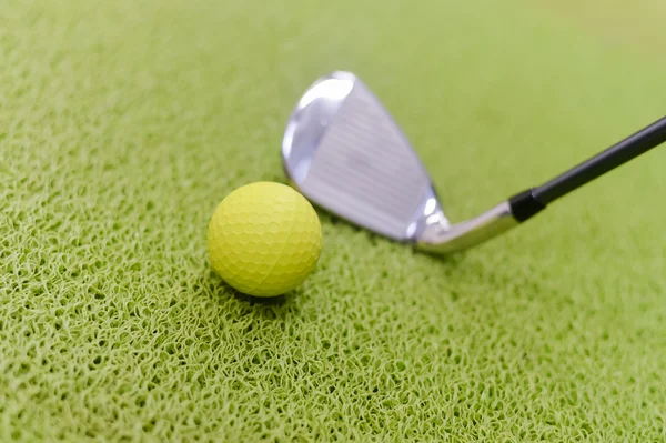 Golf club and ball on green indoor grass background — Stock Photo, Image