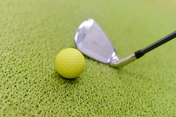 Golfschläger und Ball auf grünem Indoor-Gras Hintergrund — Stockfoto