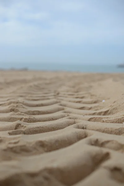 Κλείστε επάνω σε ίχνη ελαστικών σε στεγνή άμμο φόντο — Φωτογραφία Αρχείου