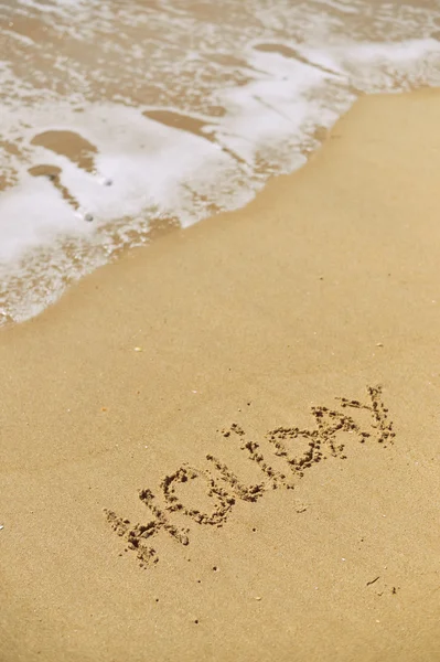 Draufsicht auf die Inschrift Urlaub am Meer Sandstrand mit den Sonnenstrahlen gegen Wellenschaum. Urlaubskonzept — Stockfoto