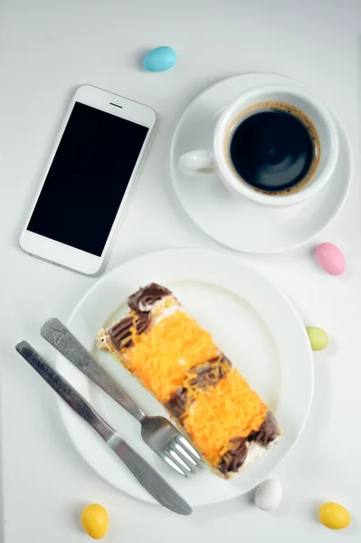 Vista superior close-up de xícara de café, telefone inteligente e bolos no fundo da mesa. Depósito plano — Fotografia de Stock