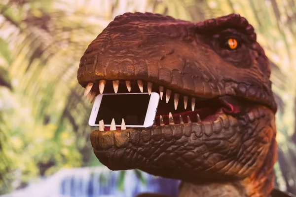 Çene, orman palmiye ağacı açık havada arka plan mobil akıllı telefon tutarak tyrannosaurus