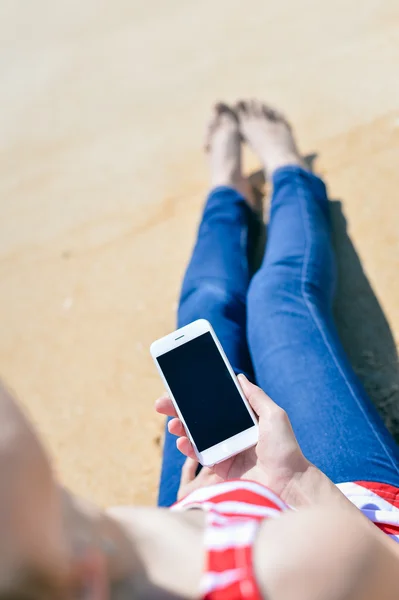 Top view of beautiful young woman using smart phone on beach — Stock Photo, Image