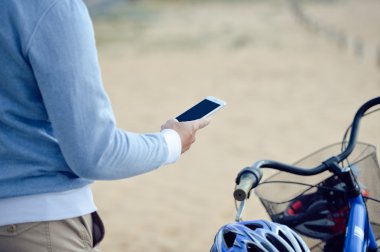 Boş ekran mobil akıllı telefon elinde, holding arka plan açık havada bisiklet ile kişi