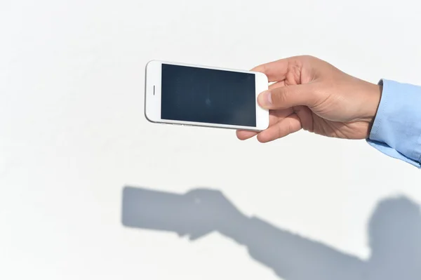 Hand hält Handy auf weißem Hintergrund. Foto Nahaufnahme — Stockfoto