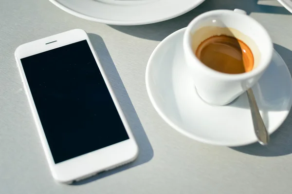 Top view of coffee cup and mobile phone on table background