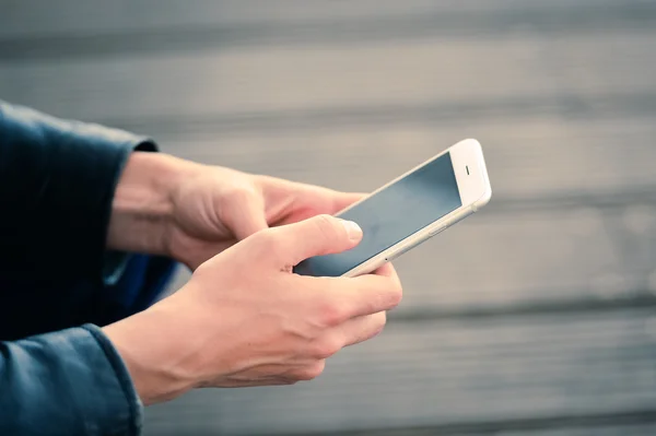 Using smartphone outdoors. Focus on the hands with phone — Stock Photo, Image