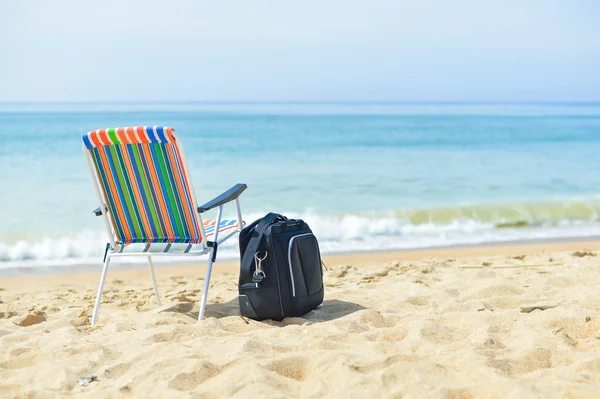 Suitcase luggage concept and beach chair on vacations, blue ocean sky background.