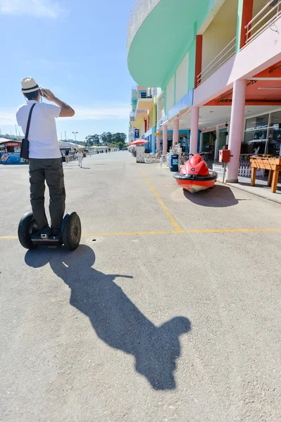 Arkadan görünüşü segway kullanarak ve cep telefonu, video fotoğraf hareket konuşurken genç adam. — Stok fotoğraf