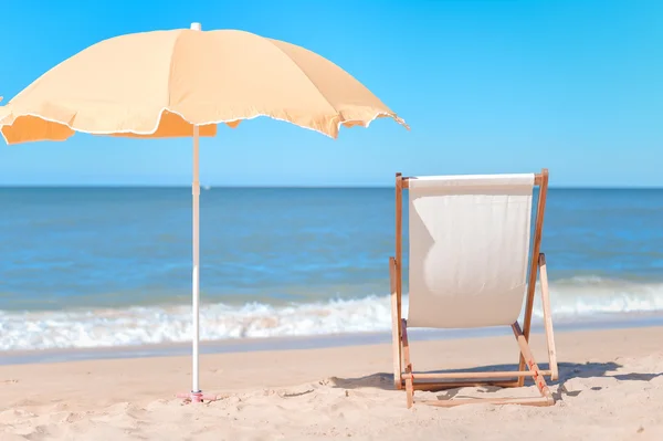 Parapluie jaune et chaise en bois sur la plage de sable de l'Atlantique — Photo