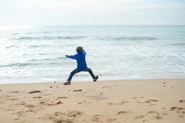 Voltar vista retrato de alegre menino bonito na praia no fundo do oceano — Fotografia de Stock