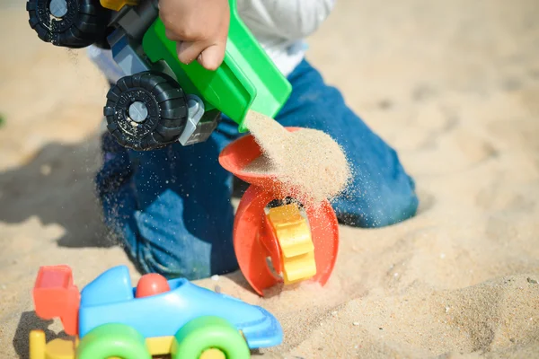 El chico se divierte al aire libre. Niño jugando juguetes en el soleado fondo del día de verano — Foto de Stock