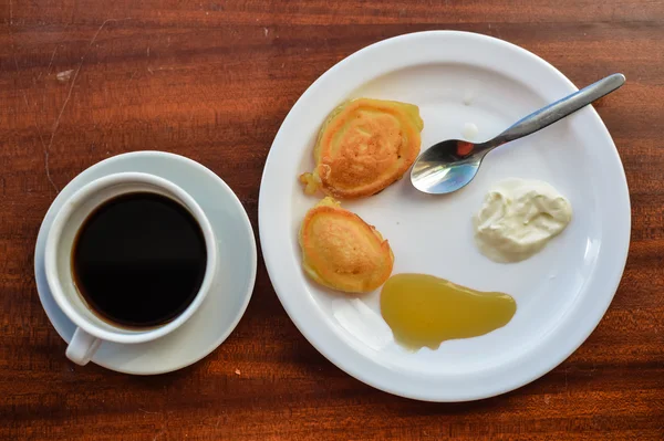 Panquecas com mel, creme e xícara de café. Vista superior . — Fotografia de Stock