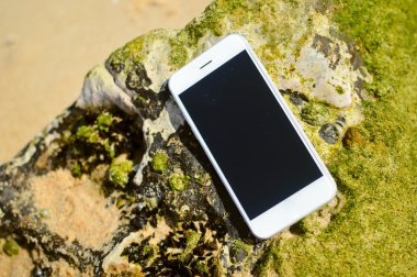 Closeup smartphone cep telefonu ile plaj arka plan üzerinde. Ana sayfa görünümü stili, fotoğraf ve video dışında
