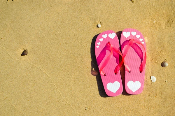 Chanclas en el fondo de la playa de arena del océano al aire libre, cálido y agradable para el tiempo de relajación — Foto de Stock