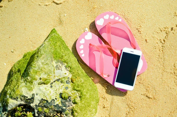 Klapki i telefon komórkowy na koncepcję wakacji plaża piaszczysta oceanu, top Zobacz płaskie świeckiego stylu — Zdjęcie stockowe