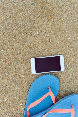 Closeup smartphone cep telefonu ile sahilde. Üst görüntülemek düz yatıyordu stili