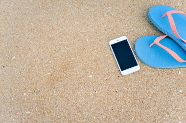 Closeup smartphone cep telefonu ile sahilde. Üst görüntülemek düz yatıyordu stili