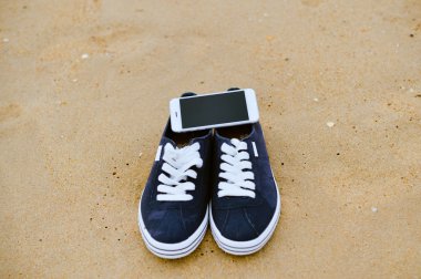 Closeup smartphone cep telefonu ile sahilde. Üst görüntülemek düz yatıyordu stili