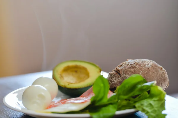 Avacado, pão, bacon e ovo com salada em prato na mesa, close up flat lay vista superior — Fotografia de Stock