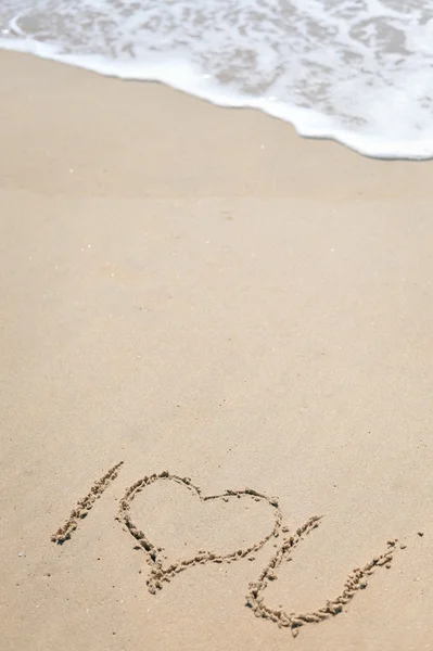 Vista superior del dibujo de la mano signo romántico en la playa de arena — Foto de Stock