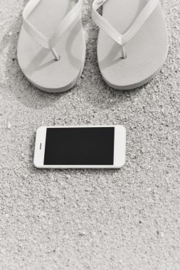 Smartphone cep telefonu ile plaj arka plan üzerinde siyah beyaz fotoğraf. Top düz yatıyordu stil closeup görüntülemek