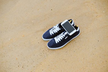 Closeup smartphone cep telefonu ile sahilde. Üst görüntülemek düz yatıyordu stili