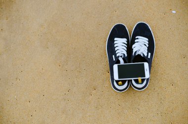 Closeup smartphone cep telefonu ile sahilde. Üst görüntülemek düz yatıyordu stili