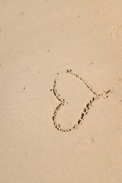 Vista superior del corazón del amor dibujado en la arena. Composición de fondo . — Foto de Stock