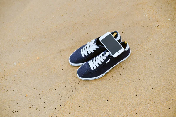 Closeup smartphone cep telefonu ile sahilde. Üst görüntülemek düz yatıyordu stili